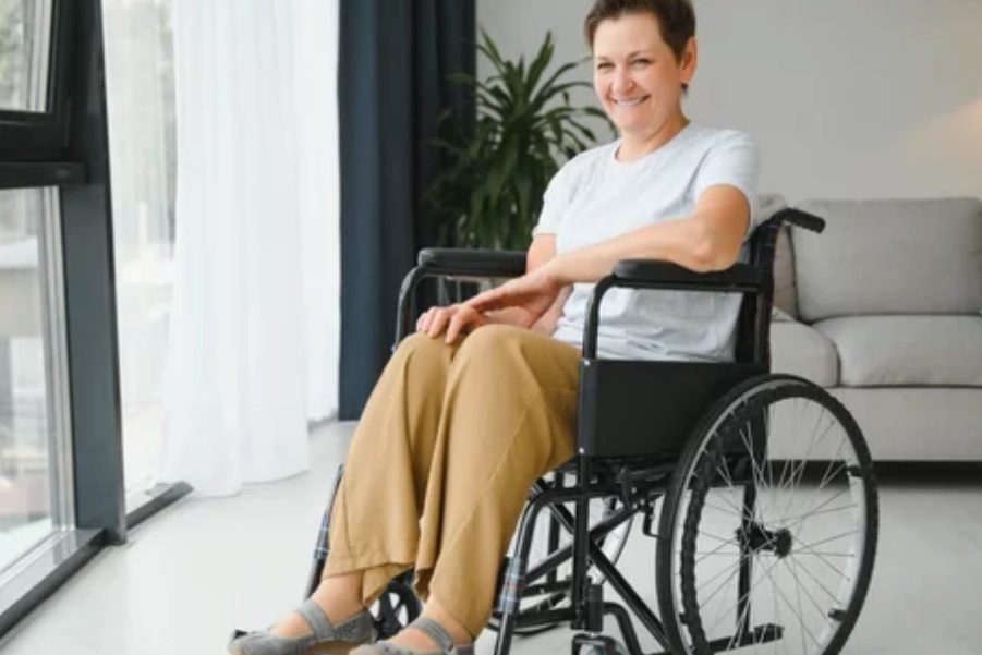 A person with a spinal cord injury working with a therapist during a rehabilitation session.